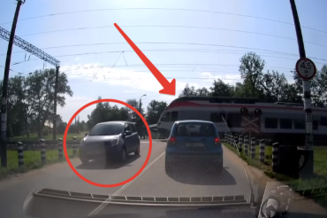 Видео: водитель поехал через пути на красный и едва не попал под поезд