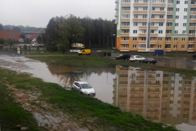 Дорогу к квартирным домам и ТЦ Ардис после дождя затопило водой